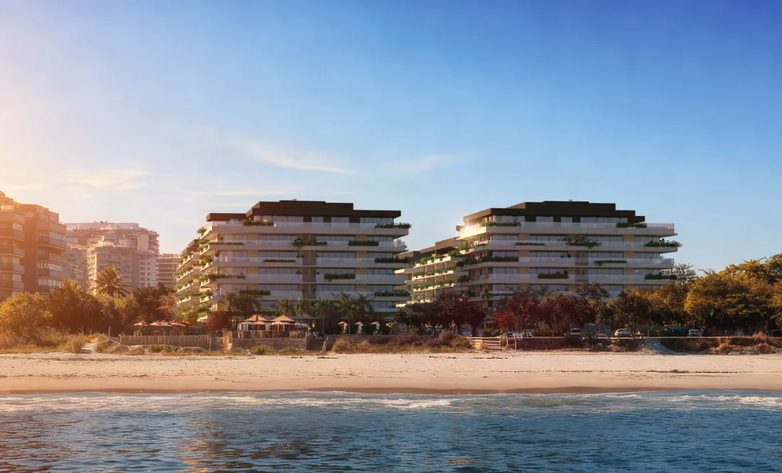 Edifícios do RIIO by Piero Lissoni vistos da areia da praia da Barra da Tijuca ao entardecer